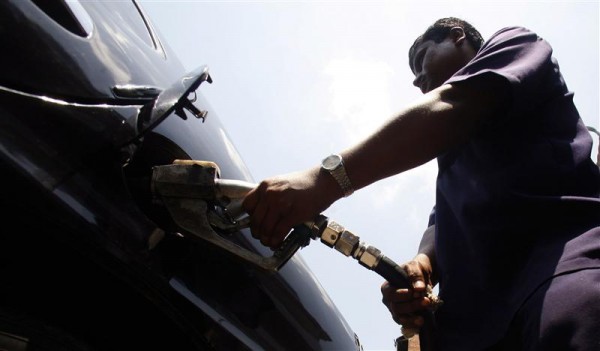 A petrol station employee pumps fuel into a car in Kolkata